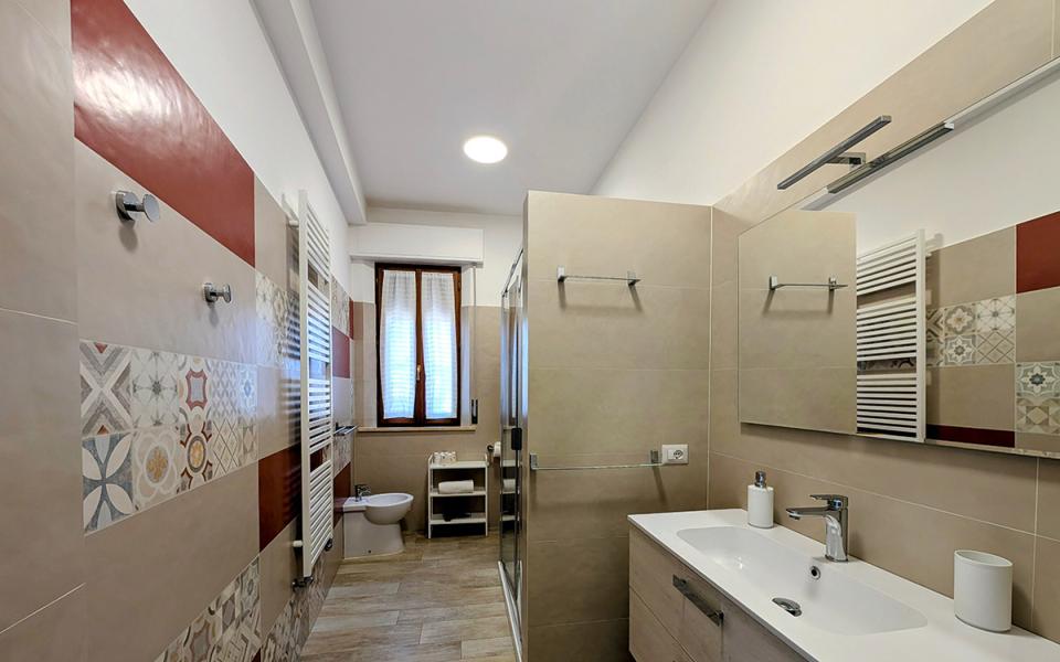 Bagno moderno e accogliente, con piastrelle colorate e arredo elegante.