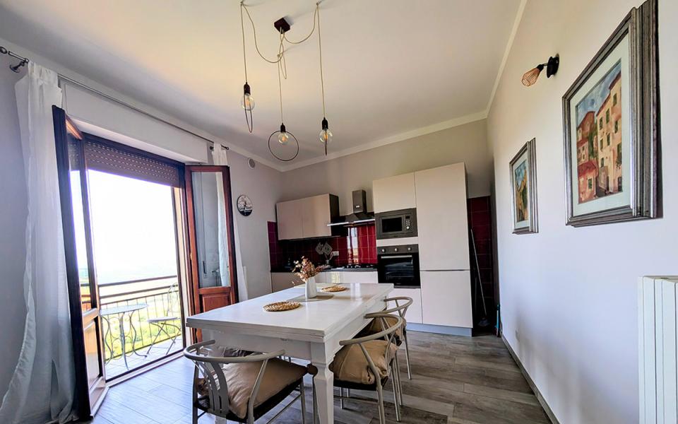 Cucina luminosa con tavolo bianco, vista panoramica e arredamento moderno, accogliente e sereno.